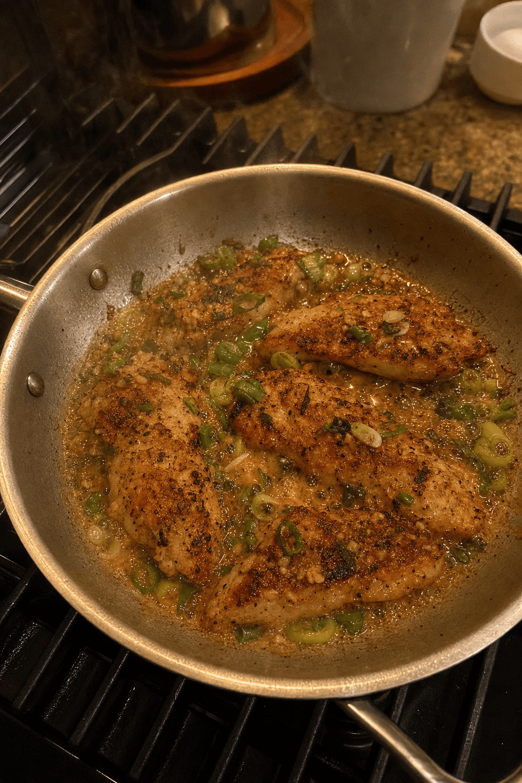 Live camera view of chicken browning in a skillet on the stove
